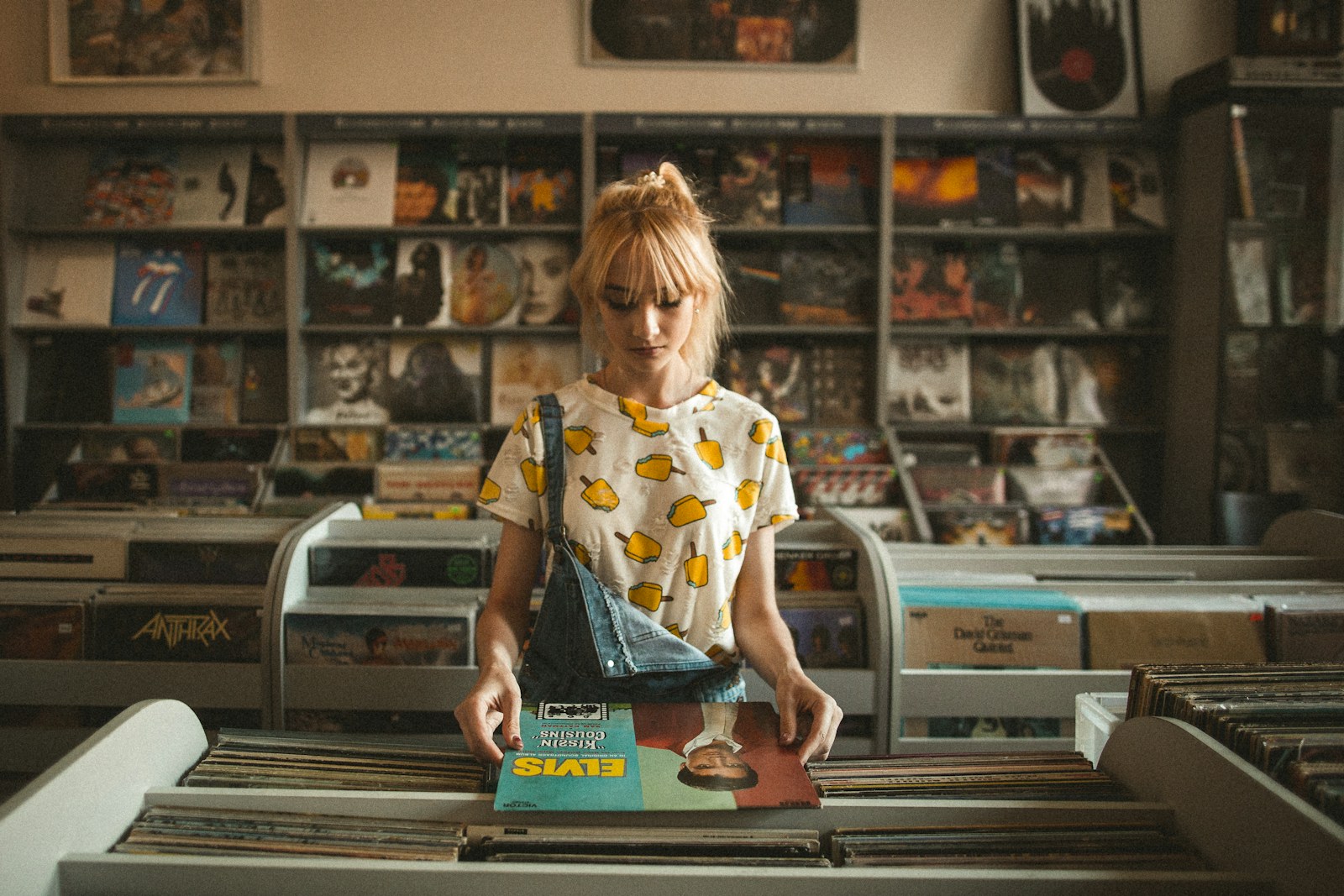 A shopper comparing an Elvis Presley record in a record store.