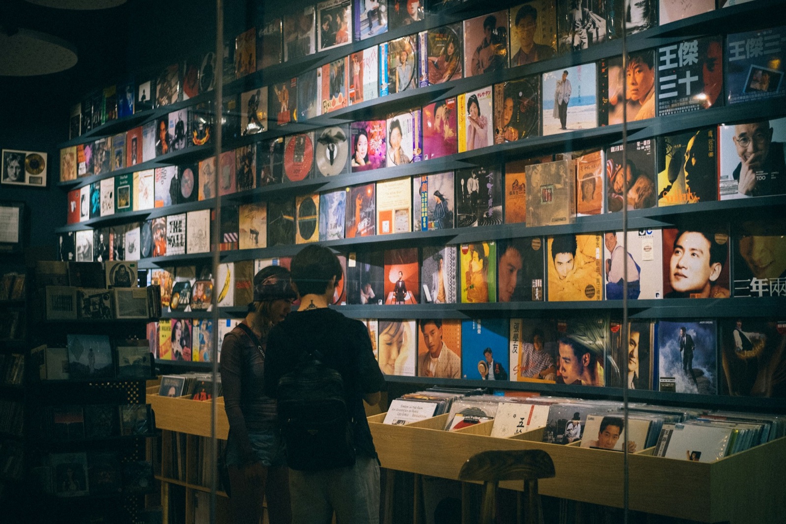 Two shoppers browsing records in a music store.